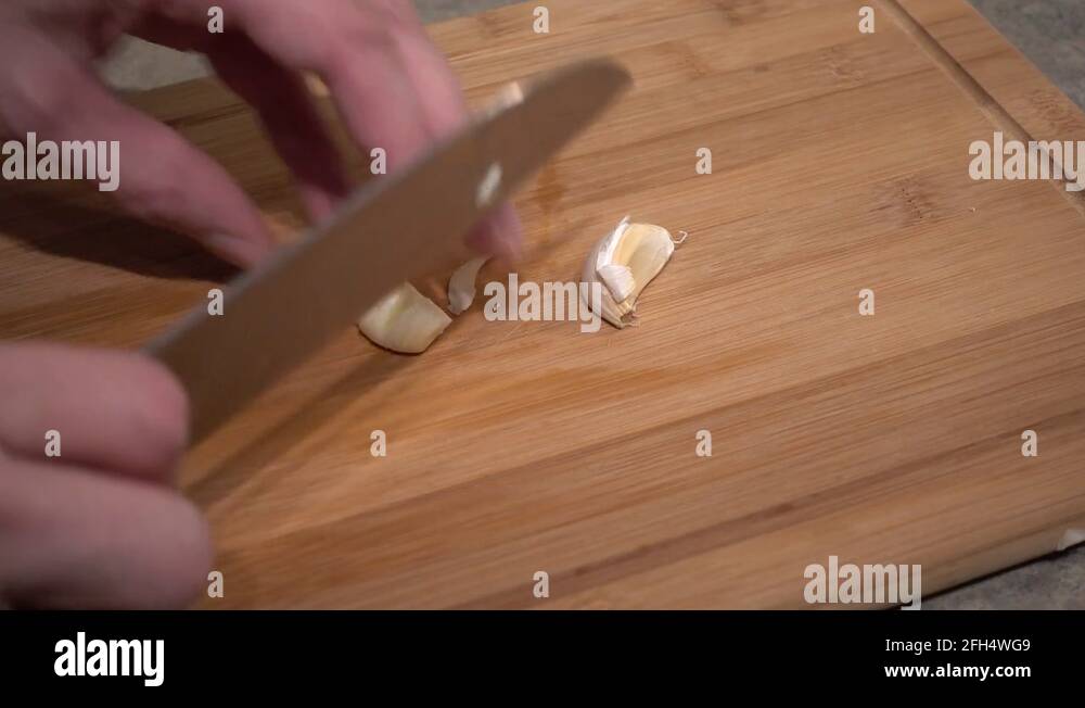 Slicing And Dicing Cubing A Piece Of Garlic On Chopping Board 4K Stock