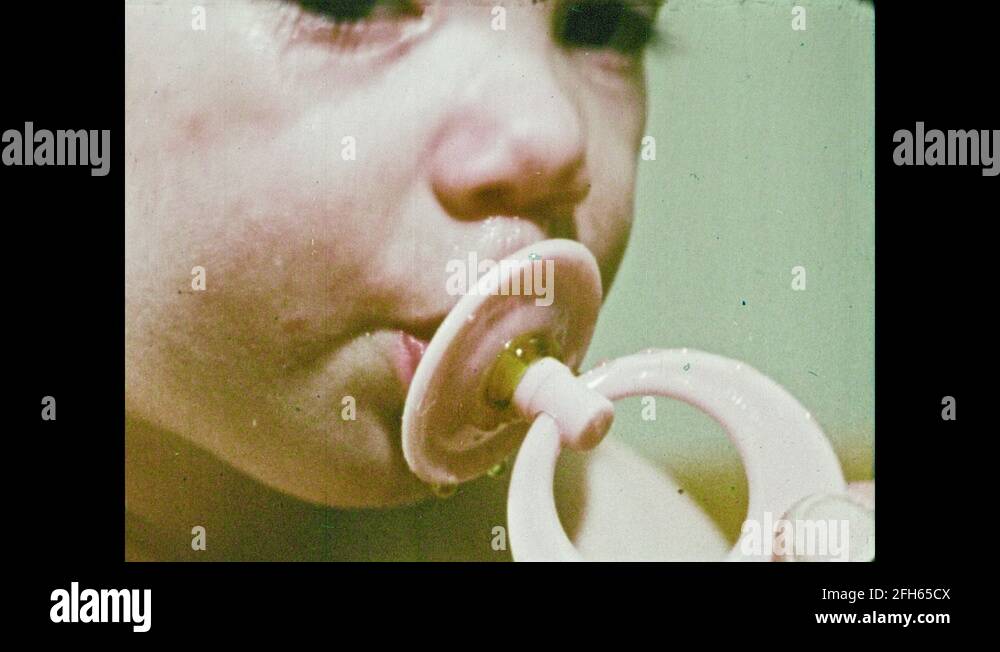 1970s Baby's feet. Baby sucks on pacifier. Falling pills. Needles