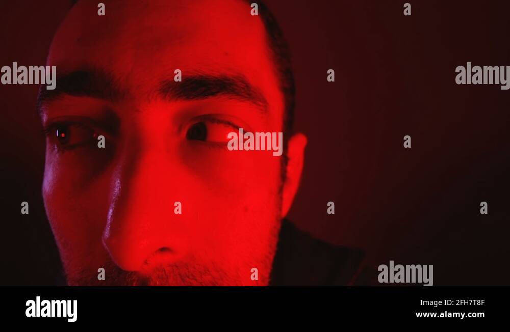 Man with shocked facial expression moves his eyes from side to side