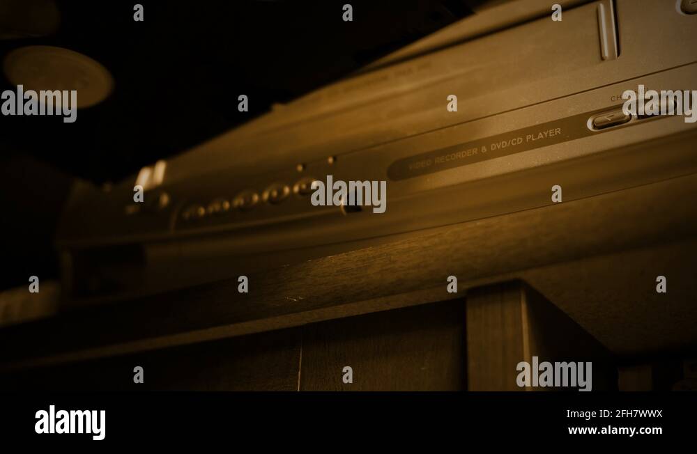 Inserting a VHS Tape into VHS player old retro color graded sepia