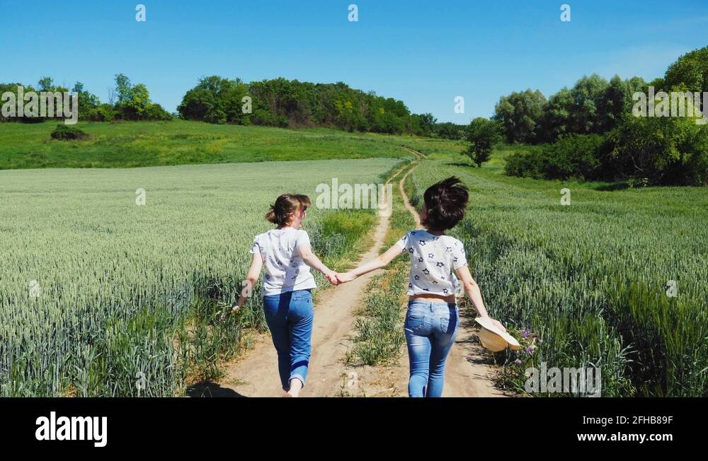 Two girls holding hands running on nature Stock Video Footage - Alamy