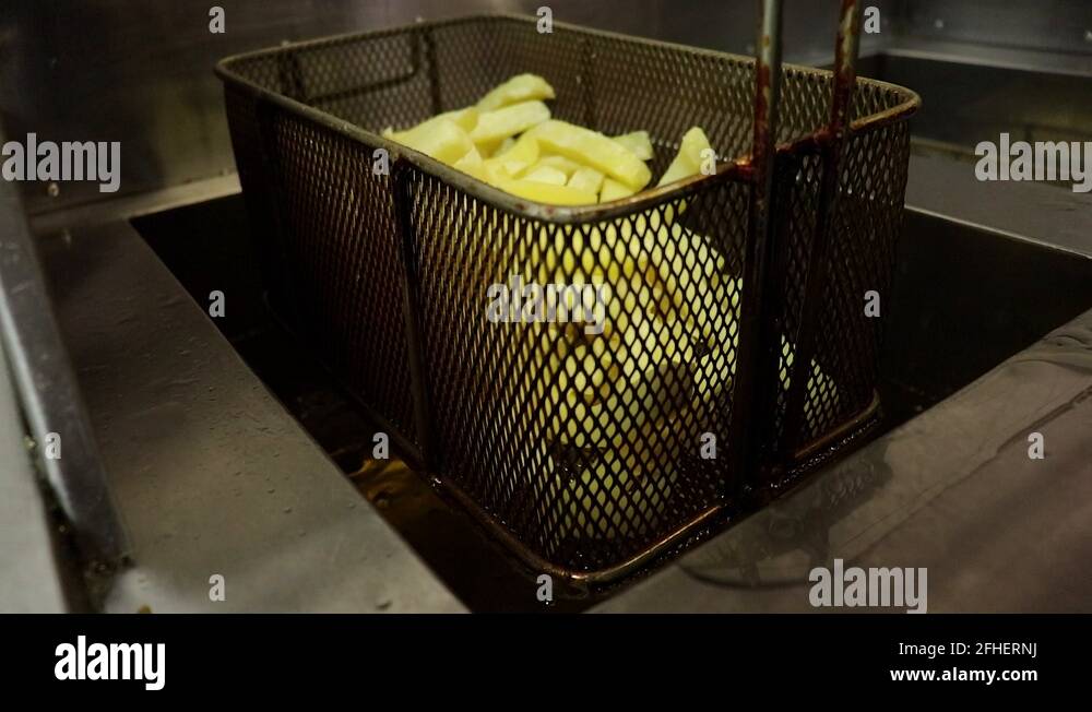 French fries being put into oil fryer Stock Video Footage Alamy