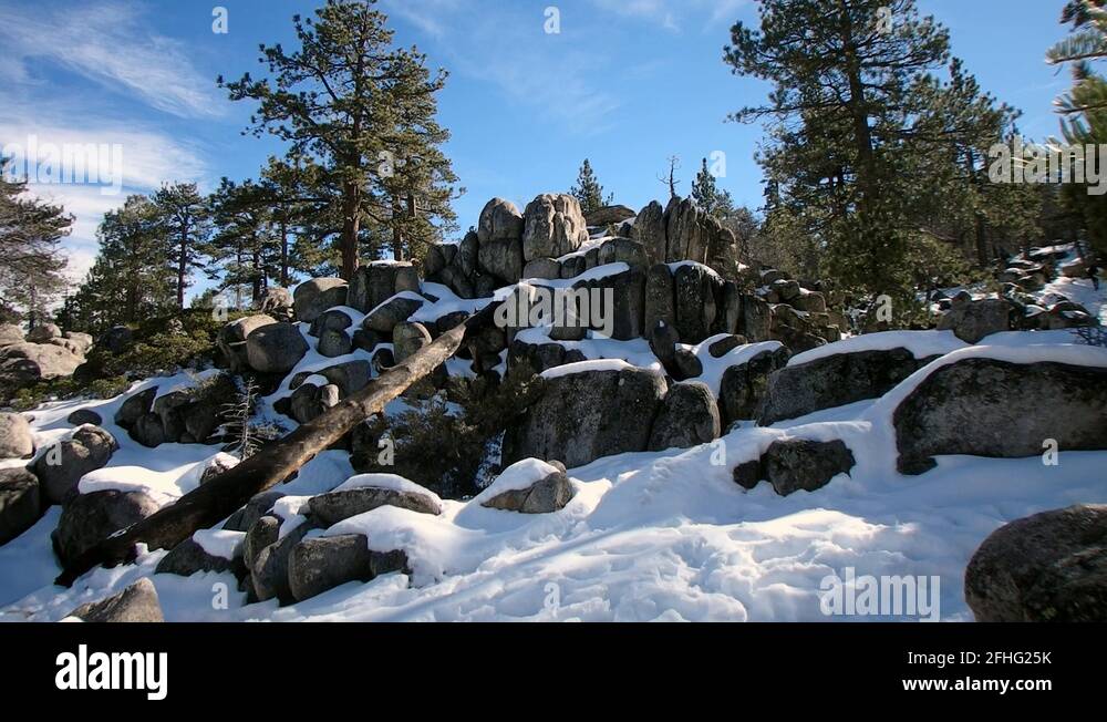 Big Bear Snow Hike wide shot of snowy rocks, hill and sky, with a man