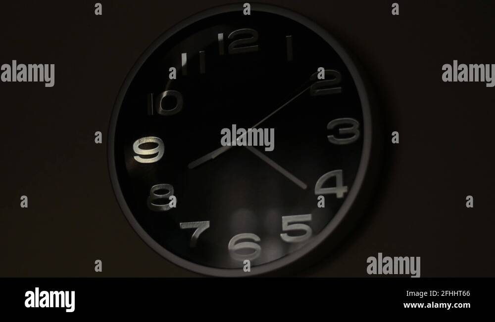 Greyblack analog clock ticking with focus change to the reflection