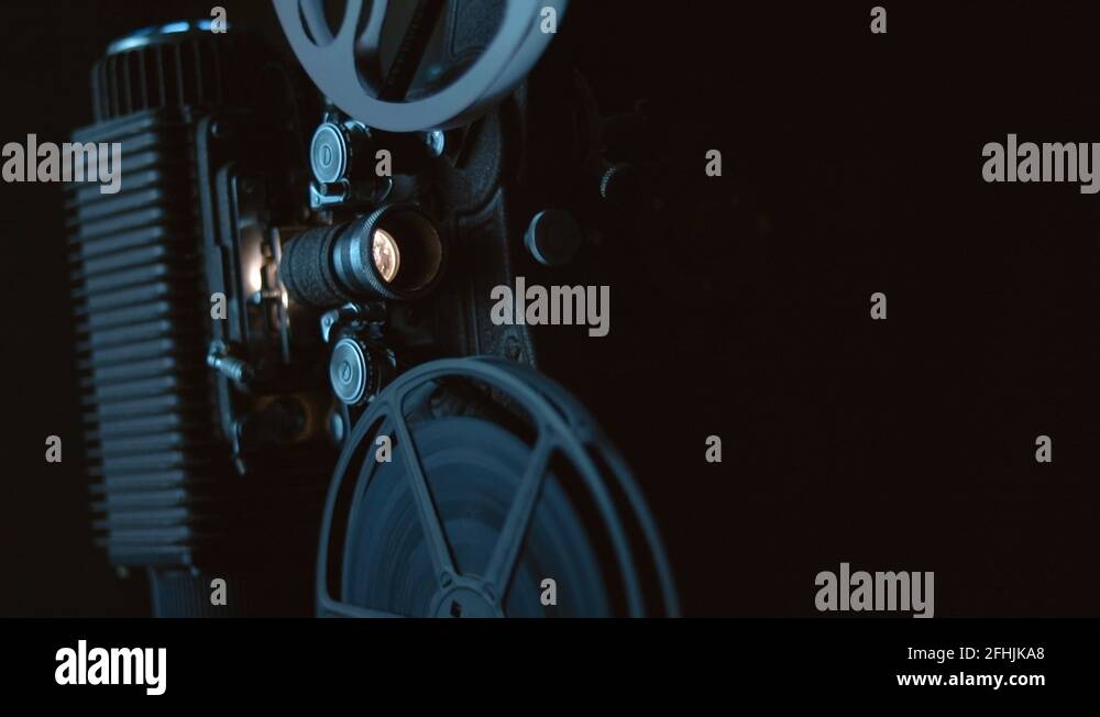 Antique working reel to reel film projector with light flicker and dust