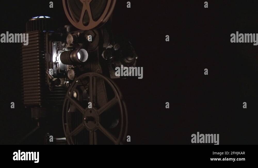 Working antique reel to reel film projector with light flicker and dust