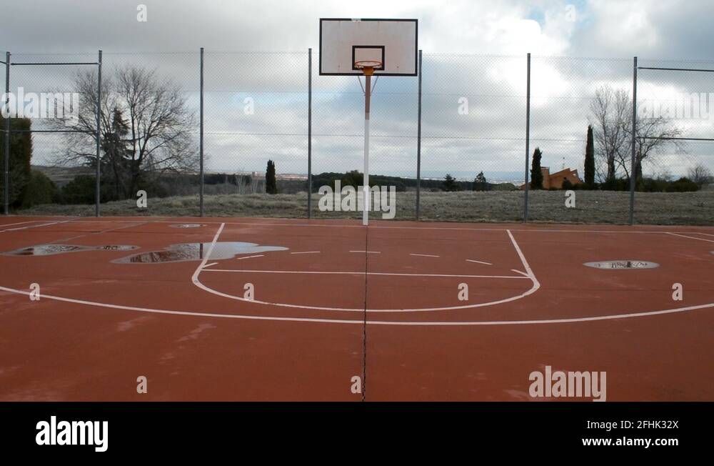 Empty outdoor basketball court with puddles on the floor. You can see a Stock Video Footage Alamy
