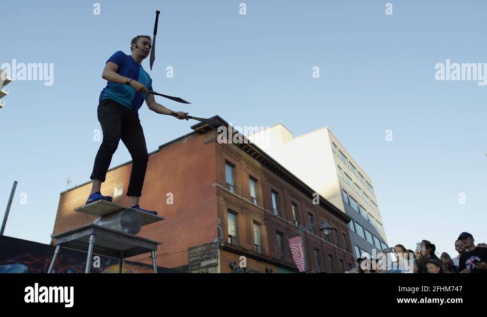 cinematic man juggling swords in front of a city crowd Stock Video