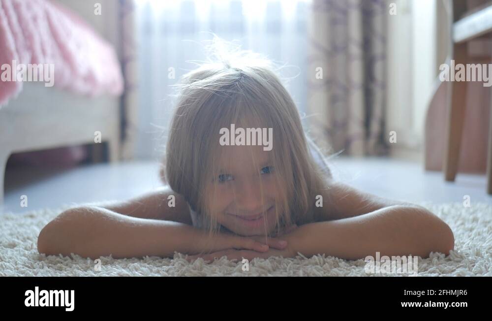 Pretty little girl lying on floor and smiling Stock Video Footage - Alamy