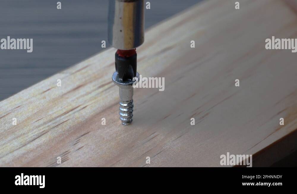 A wood screw being driven into wood in slow motion Stock Video Footage