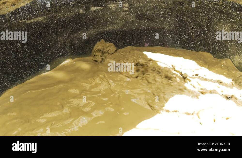Mud water splashing in mud bath in spa resort close up. Mud bath for