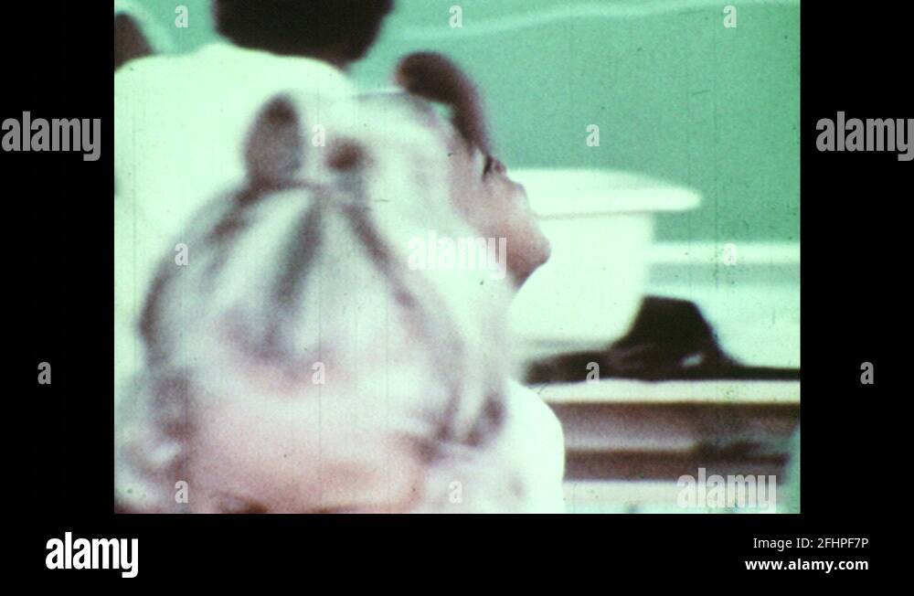 1970s: Boy walks through classroom and cries. Woman kneels and consoles ...