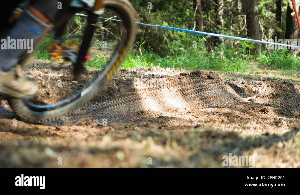 A mountain biker’s wheels digging into the dirt trail during the