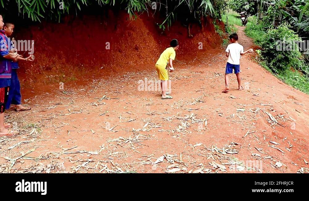 Hmong hill tribe children playing traditional game spinning tops Stock
