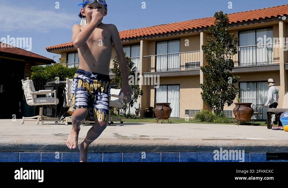 boy jumps into hotel pool slow motion Stock Video Footage Alamy