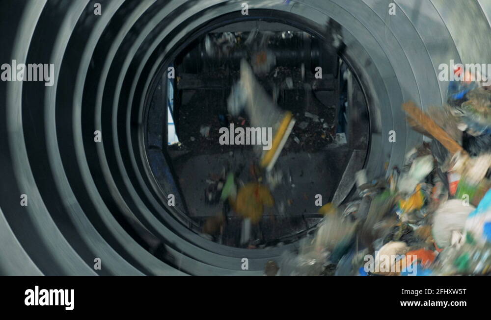 Process of mechanical garbage sorting. Trash falls from a conveyor into