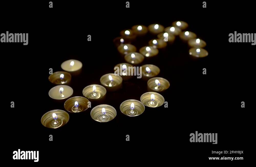 real flames of little candles are flickering in darkness, depicting a