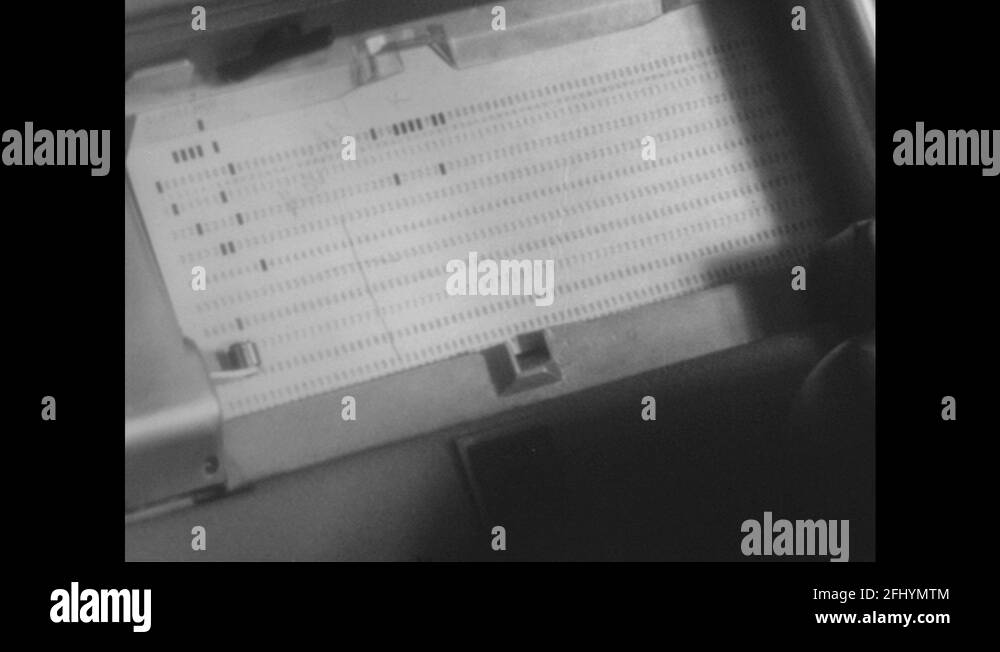 1960s Punch card in machine. Close up, hand holding stack of punch