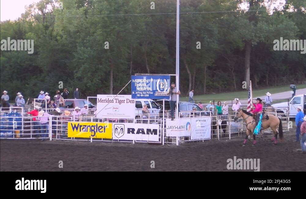 Topeka rodeo American flag horse rider passes on the far side of the