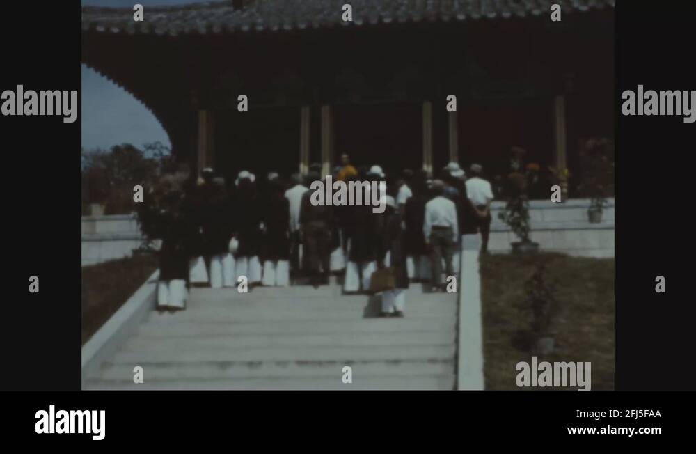 Soldiers and Vietnamese civilians walk up to Buddhist shrine for prayer