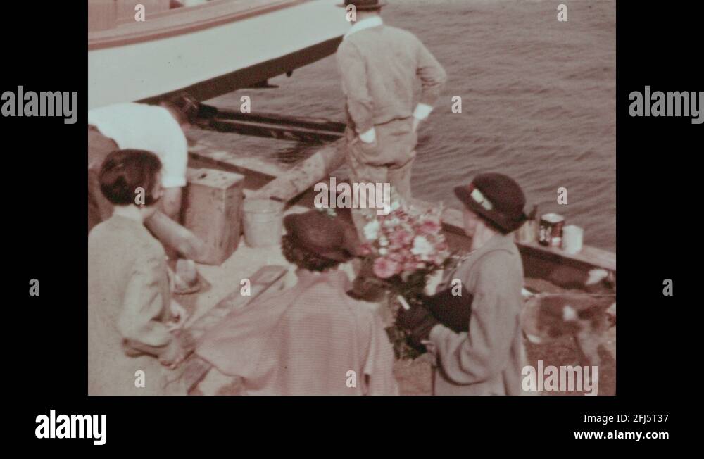 1930s Woman and man christen ship with bottle of champagne. Men