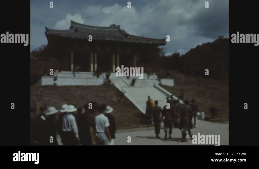 Soldiers and Vietnamese civilians walk up to Buddhist shrine for prayer