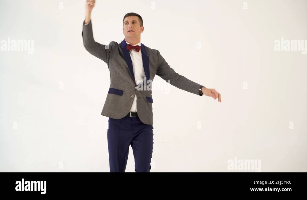 humorist in gray suit with red bow tie is dancing in the similitude of