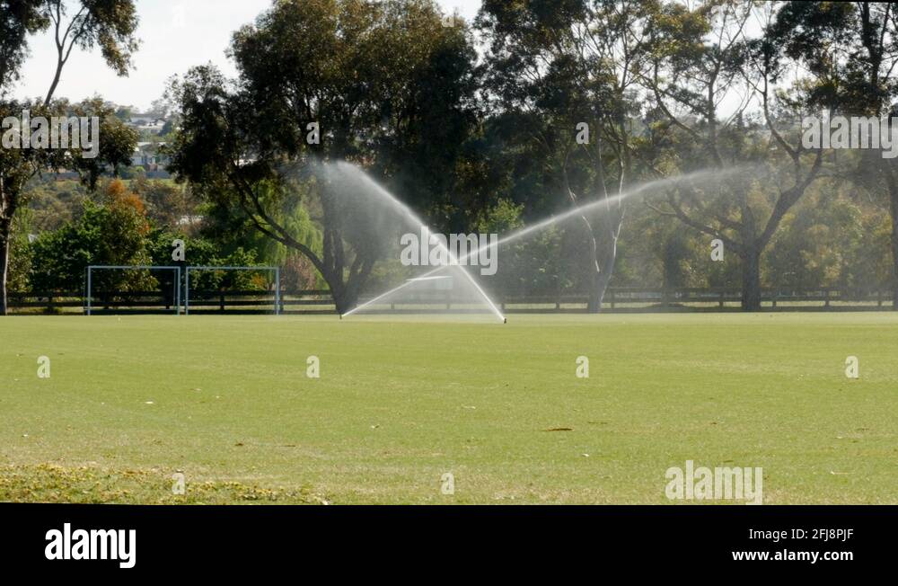 Sprinkler irrigation system spraying water on a cricket field in