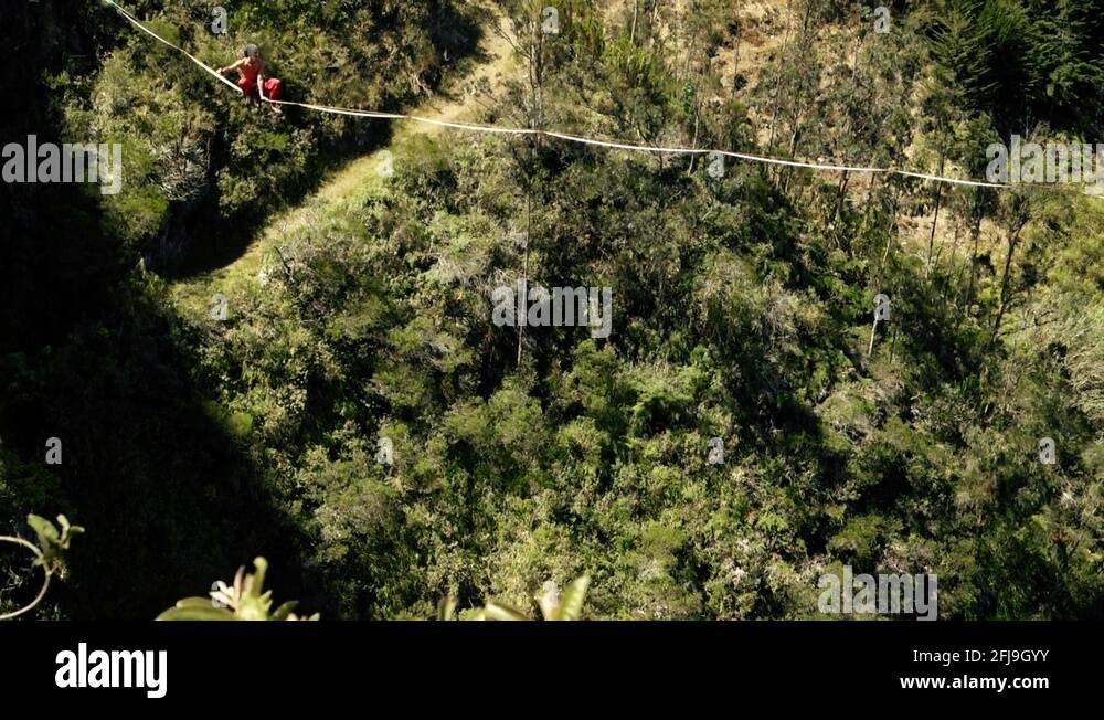 extremely male balancing on slack line or tightrope high above the ground with Stock Video