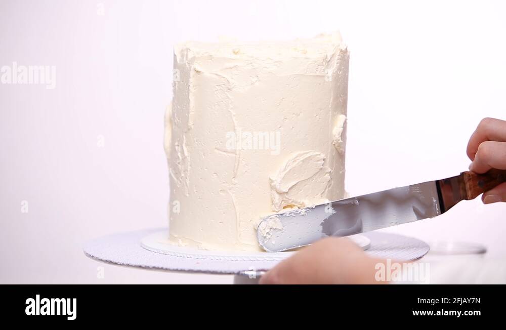 Icing tall birthday cake with white buttercream icing Stock Video