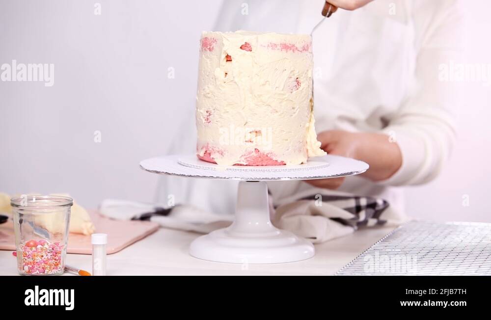 Icing tall birthday cake with white buttercream icing Stock Video