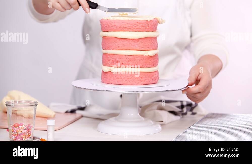 Icing tall birthday cake with white buttercream icing Stock Video