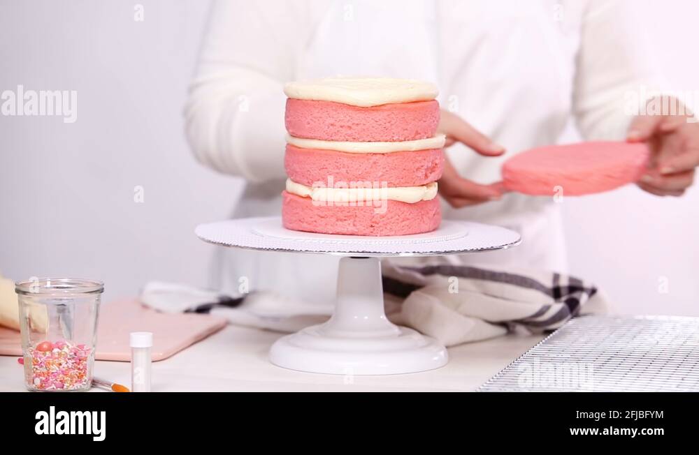 Icing tall birthday cake with white buttercream icing Stock Video