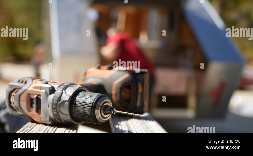 A hand grabbing a cordless drill with a drill bit as a construction
