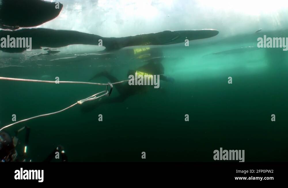Technical diver with underwater cameraman under ice of lake Baikal