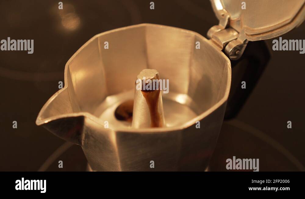 Brewing espresso coffee in moka pot first coffe spitting out slowly