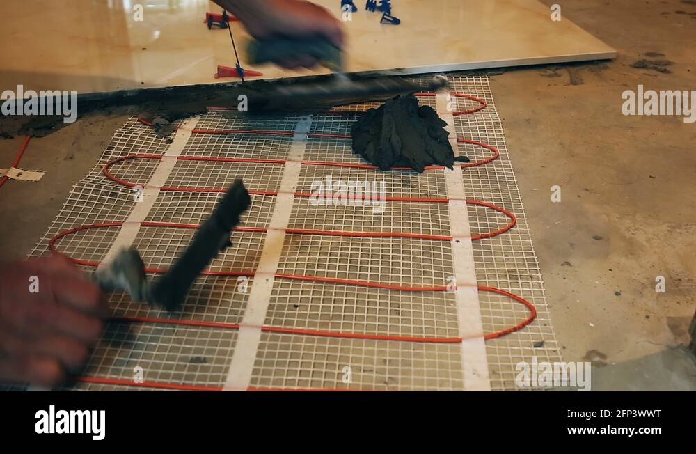 Installation of heated floor. Laying a ceramic or porcelain tile floor close Stock Video Footage