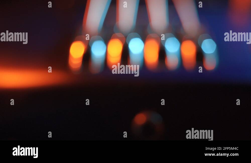 Piezo bridge of a fretless electric bass guitar, red and blue lighting