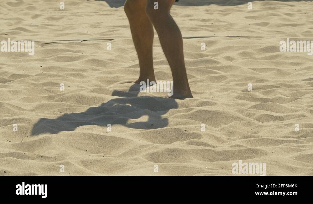 A man diving and digging a ball in a beach volleyball game match in the