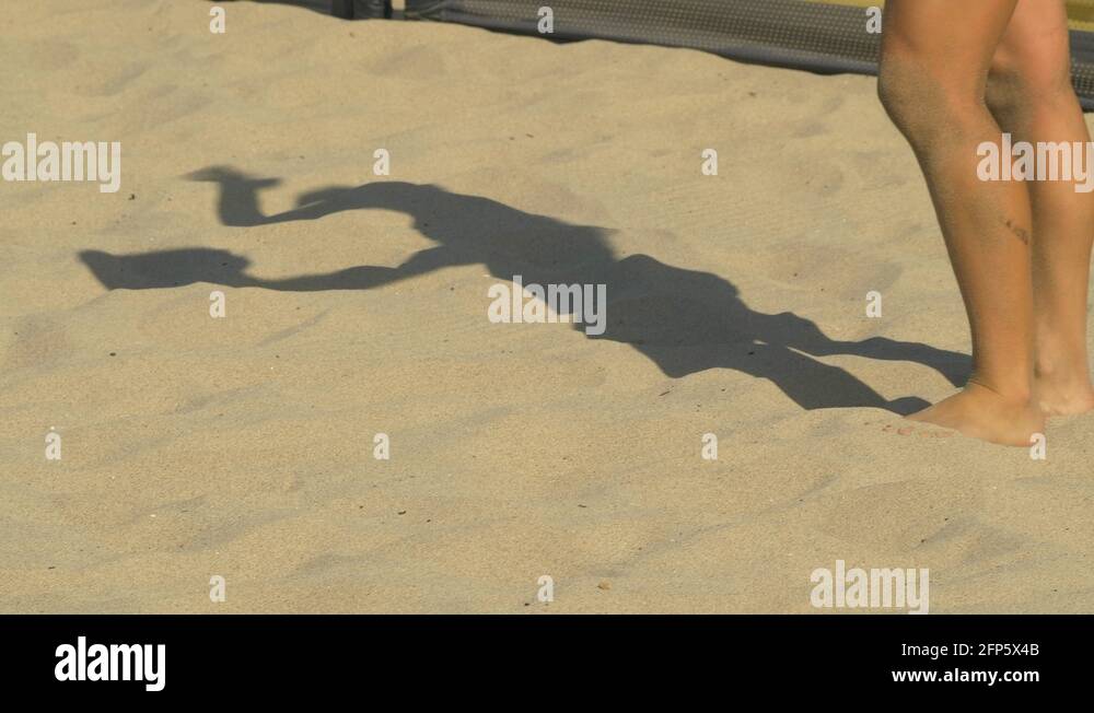 Women serve serving while playing pro beach volleyball in the sand