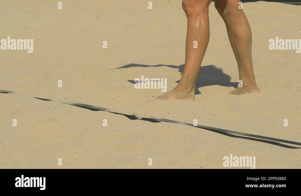 Women serve serving while playing pro beach volleyball in the sand