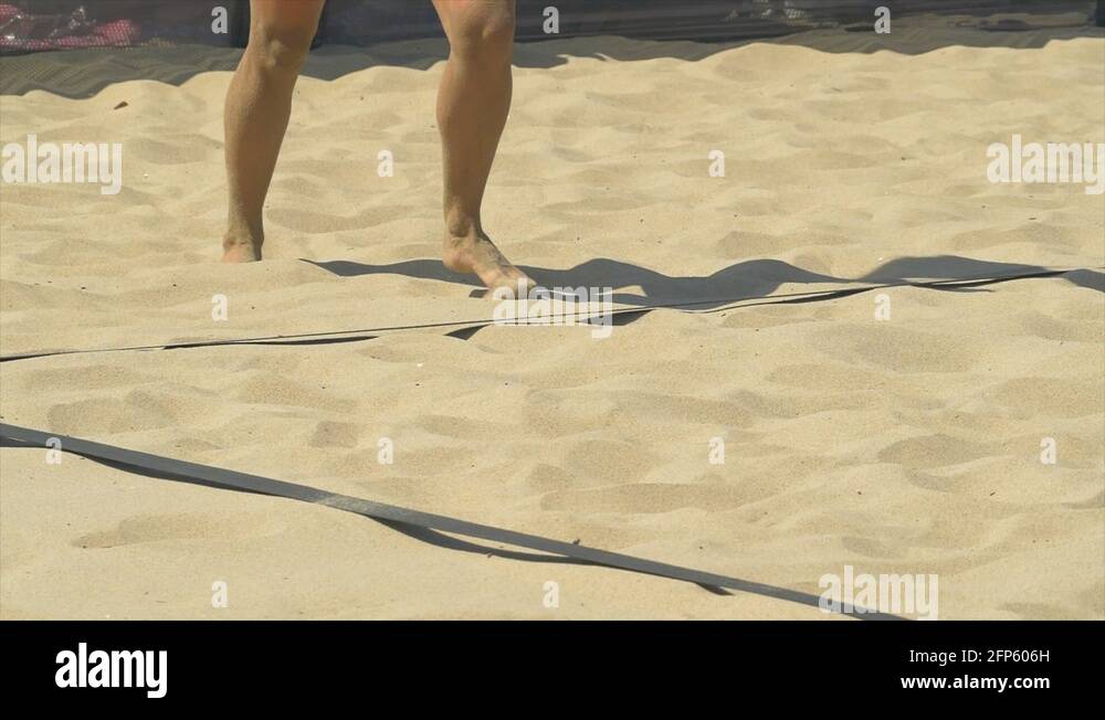 Women serve serving while playing pro beach volleyball in the sand