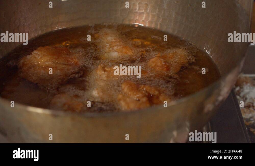 a Japanese female chef deep frying chicken thigh for Japanese style