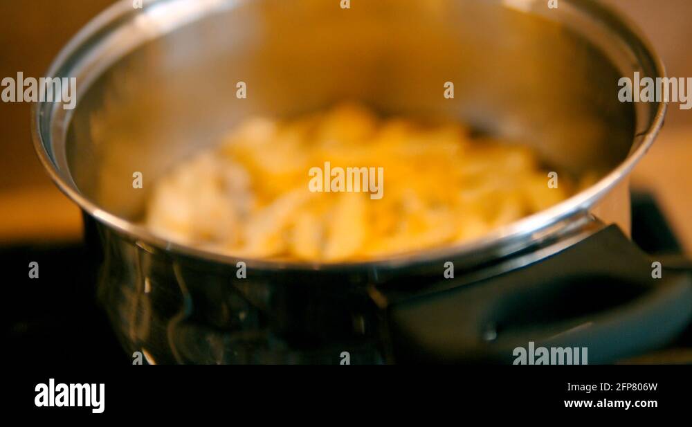 Greasy, fattening deep fried chips bubbling in stainless steel pan