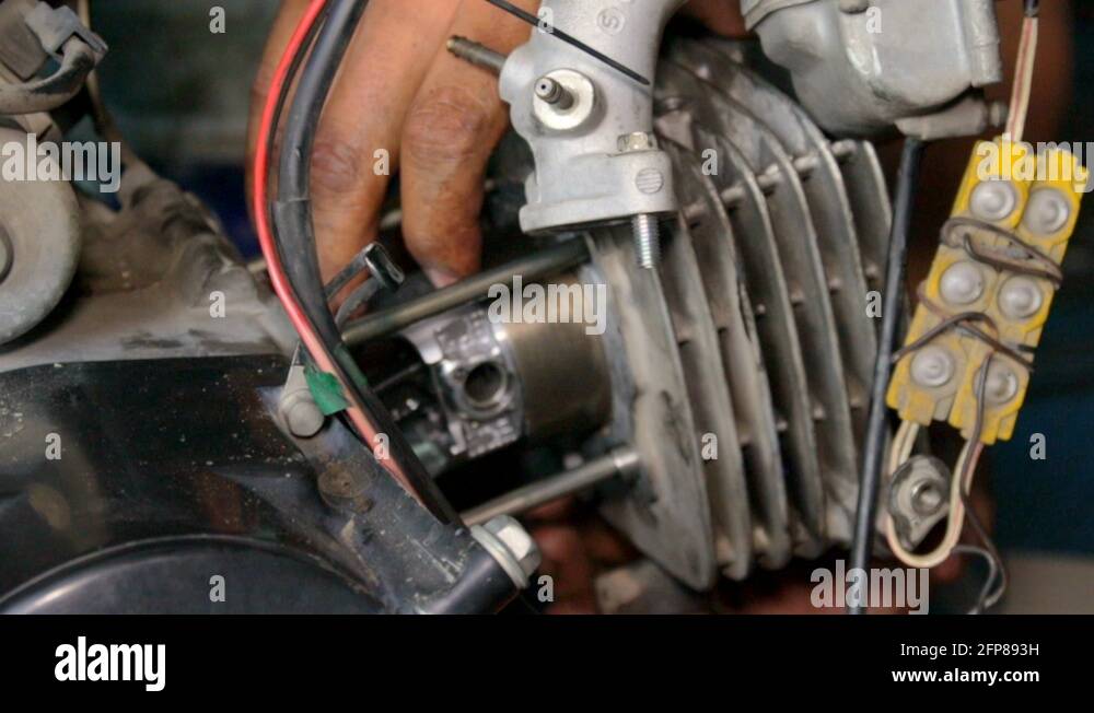 Mechanic pushing in motorcycle gasket sealer in place. locked off