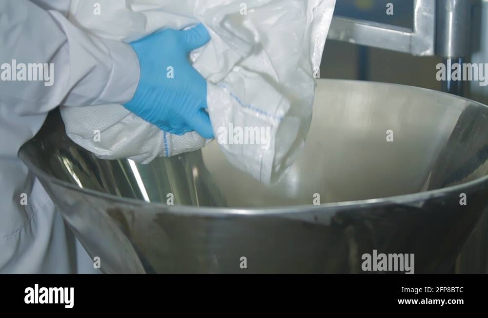Dry powder is poured from the bag into the mixing tank at the factory