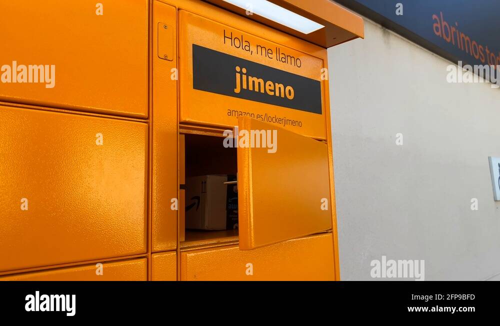 A man's hand picking up a package at the Amazon hub Locker pick up