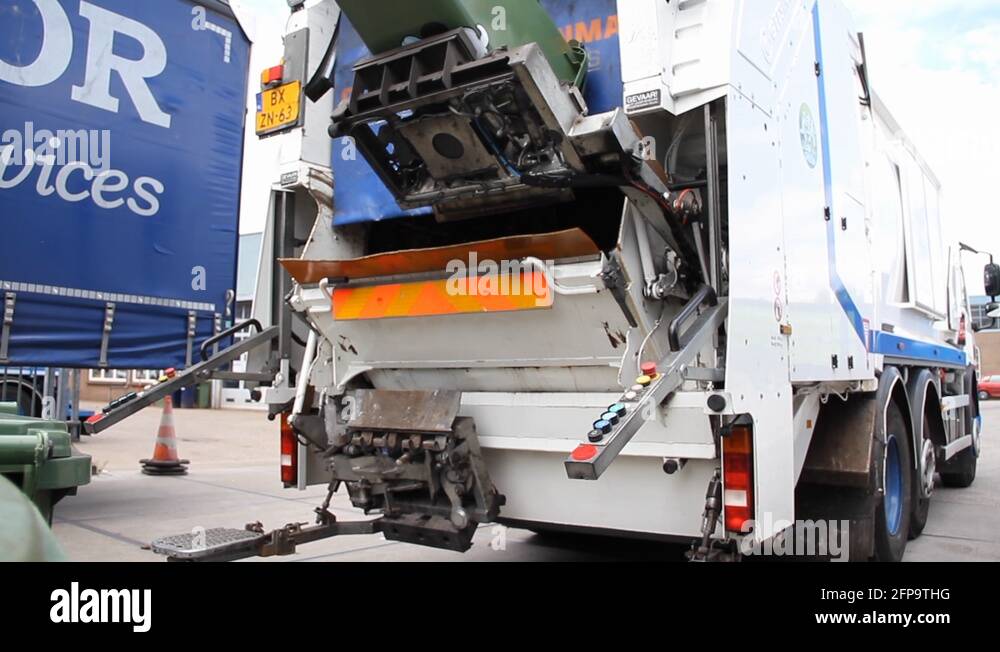 Trash bin being emptied in garbage truck and collector emptying new bin Stock Video Footage Alamy