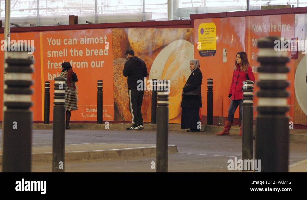 People stand six feet apart local grocery store in london during pandemic stock video footage 