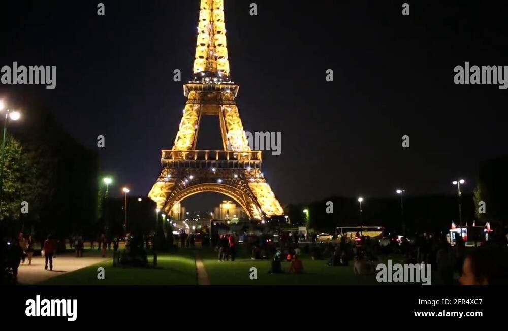 People near Eiffel Tower at night in Paris, France Stock Video Footage